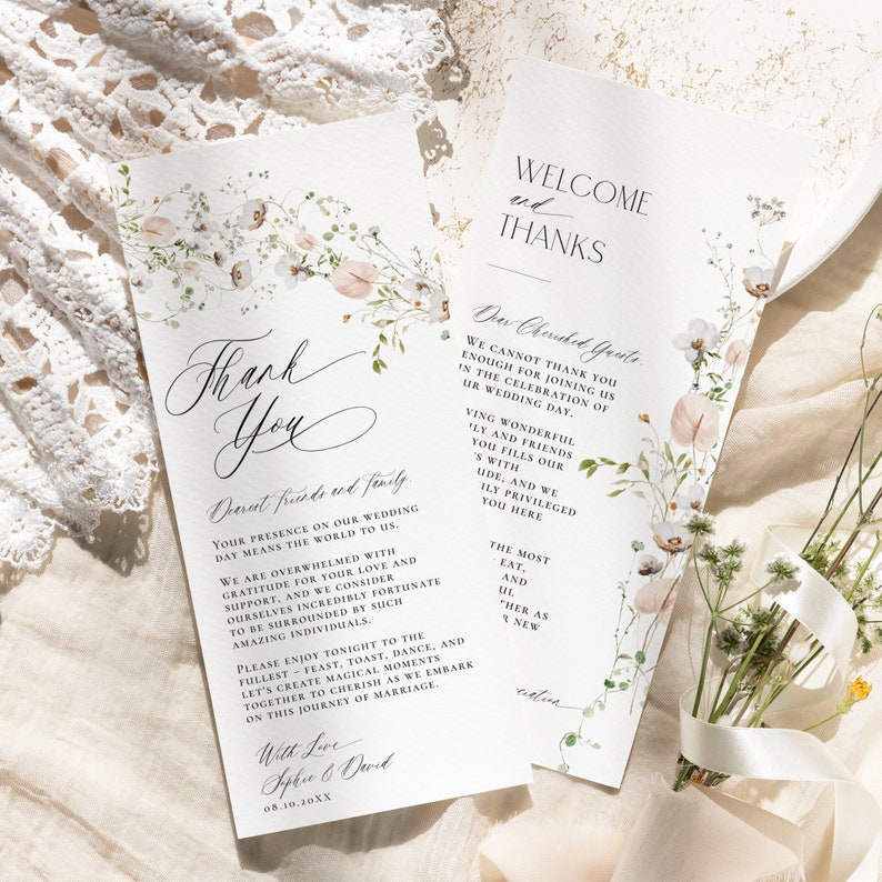 May include: Two white wedding program cards featuring delicate watercolor floral illustrations in soft pink and green tones. The text includes "Thank You," "Welcome and Thanks," and "Dear Cherished Guests," with elegant black typography printed on textured paper.