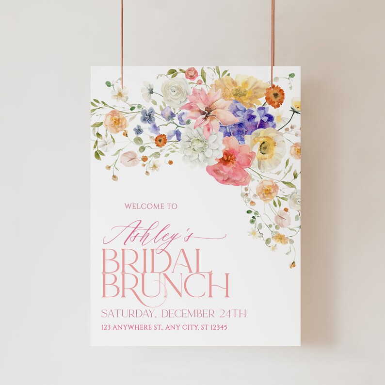 Pu&ograve; includere: Un cartello di benvenuto per un brunch di nozze floreale con un design ad acquerello di fiori rosa, gialli e blu. Il testo recita "Benvenuti al brunch di nozze di Ashley, sabato 24 dicembre, 123 Anywhere St., Any City, ST 12345".