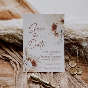 May include: A rectangular Save the Date card featuring floral illustrations in muted tones, the names Jessica Hooper and Richard Anderson, and event details. A gold wax seal stamp and three small wax seals are placed near the card.