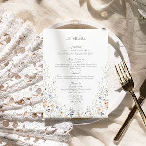 Puede incluir: Un men&uacute; de boda con un dise&ntilde;o floral. El men&uacute; incluye aperitivos, plato principal, ensalada y postres. El texto dice "the MENU", "Appetizer", "PASSED HORS D'OEUVRES", "Mini Lobster Tacos with Avocado Crema", "Caprese Skewers with Balsamic Glaze", "Main Course", "DUO ENTR&Eacute;E", "Grilled Filet Mignon with Red Wine Demi-Glace", "Herb Roasted Chicken Breast with Lemon Herb Butter Sauce", "Salad", "Mixed Greens Salad with Candied Pecans, Goat Cheese, and Raspberry Vinaigrette", "Desserts", "DESSERT BAR", "Assorted Miniature Desserts such as Chocolate Truffles, Macarons, and Fruit Tarts", "CHARLOTTE", "JASON", "27TH JUNE 20XX".