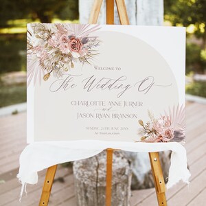 May include: A wedding welcome sign with a beige background and a floral design in shades of pink and brown. The text reads "Welcome to The Wedding Of Charlotte Anne Jurner and Jason Ryan Branson Sunday, 24th June 20XX At This Location".