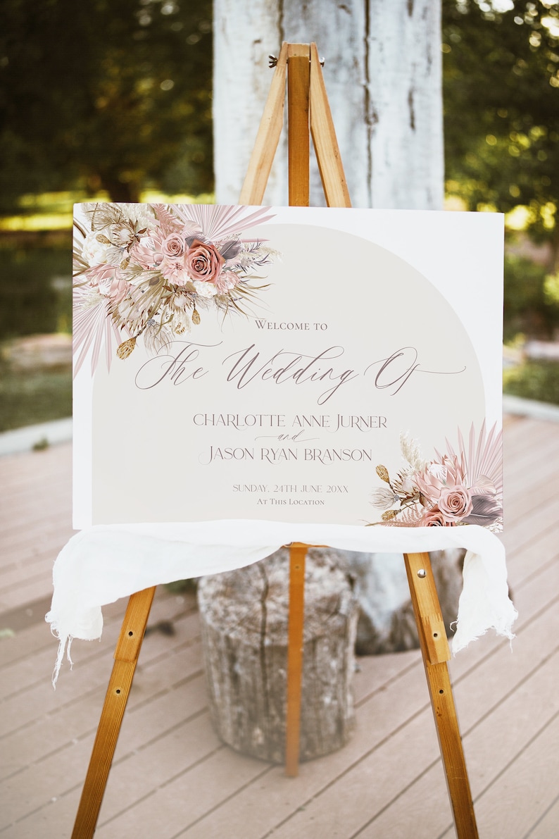 May include: A wedding welcome sign with a beige background and a floral design in shades of pink and brown. The text reads "Welcome to The Wedding Of Charlotte Anne Jurner and Jason Ryan Branson Sunday, 24th June 20XX At This Location".