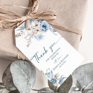 Pu&ograve; includere: Un'etichetta regalo rettangolare bianca con un motivo floreale nei toni del blu e del beige, con il testo Thank you for celebrating with us with love Jessica & Richard 09.25.20xx, legata con rafia a un regalo avvolto in carta marrone.