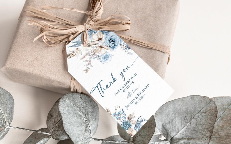 Pu&ograve; includere: Un'etichetta regalo rettangolare bianca con un motivo floreale nei toni del blu e del beige, con il testo Thank you for celebrating with us with love Jessica & Richard 09.25.20xx, legata con rafia a un regalo avvolto in carta marrone.