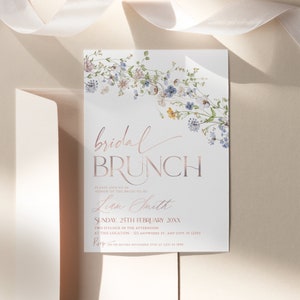 May include: A white bridal brunch invitation with a floral border. The text reads "bridal brunch" in a rose gold font. The invitation is for Liam Smith and is for Sunday, 25th February 20XX at 2:00 PM. The RSVP date is 15th November.