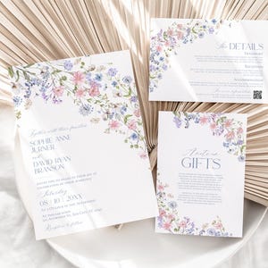 K&ouml;nnte beinhalten: Ein Set aus drei wei&szlig;en Hochzeitseinladungskarten mit zarten Aquarellillustrationen von rosa und blauen Wildblumen. Der Text enth&auml;lt die Namen Sophie Anne Jurner und David Ryan Branson sowie Abschnitte f&uuml;r Details und Geschenke.