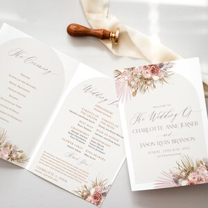 May include: Wedding ceremony program with a floral design featuring pink and white flowers, greenery, and gold accents. The program includes the order of events, the names of the wedding party, and the date of the wedding. The text reads "Welcome to The Wedding of Charlotte Anne Jurner and Jason Ryan Branson Sunday, 24th June, 20XX At This Location."