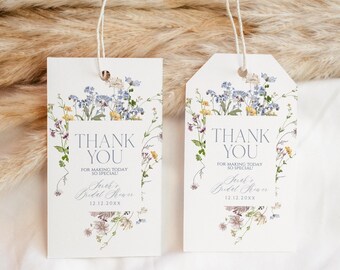 May include: Two white thank you tags with a floral design featuring blue and yellow flowers. The text on the tags reads "Thank You for making today so special!" and includes the text "Sarah's Bridal Shower 12.12.20XX".