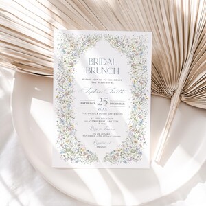 May include: A white bridal brunch invitation with a floral border. The invitation features the text "Bridal Brunch", "Please join us to celebrate the bride-to-be", "Sophie Smith", "Saturday 25 December 20XX", "Two o'clock in the afternoon", "At this location", "LY Anywhere St. Any City", "RSVP to Vanessa", "On or before November 1st at (123) 457 890", "Register at Amazon".