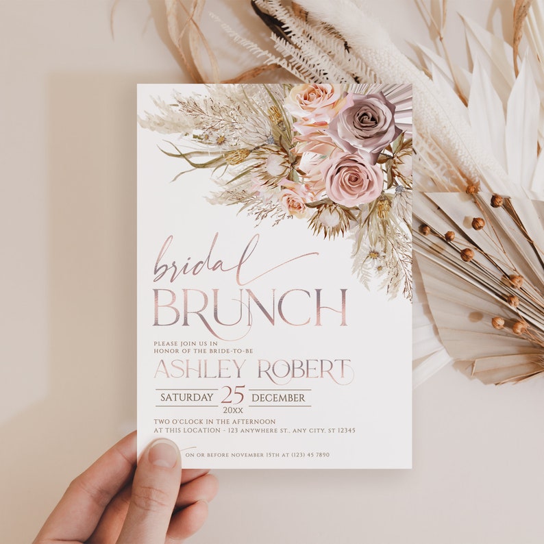 May include: A white bridal brunch invitation with a pink and brown floral design. The text reads "bridal brunch" in a pink script font. The invitation includes the bride-to-be's name, the date, and the time of the event. RSVP information is also included.