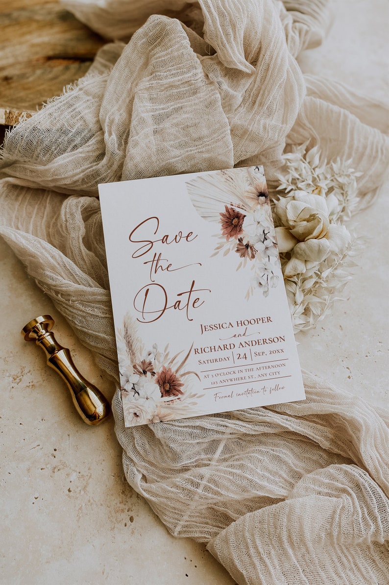 May include: A white Save the Date card featuring floral illustrations in shades of burgundy and beige. The text reads: Save the Date, Jessica Hooper and Richard Anderson, Saturday 24 Sep, 20xx, at 3 o'clock in the afternoon, 123 Anywhere St., Any City, Formal invitation to follow.