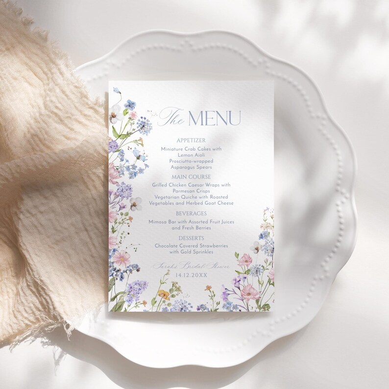 K&ouml;nnte beinhalten: Eine florale Hochzeitsmen&uuml;karte mit einem Aquarelldesign mit blauen, rosa und gelben Blumen. Das Men&uuml; umfasst Vorspeisen, Hauptgericht, Getr&auml;nke und Desserts. Der Text lautet "The Menu" und enth&auml;lt das Datum "14.12.20XX".