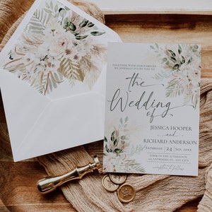 May include: A wedding invitation card and matching envelope featuring a floral and pampas grass design. The text reads: The Wedding of Jessica Hooper and Richard Anderson, Saturday 24 Sep, 20xx. A gold wax seal stamp and three circular wax seals are included.
