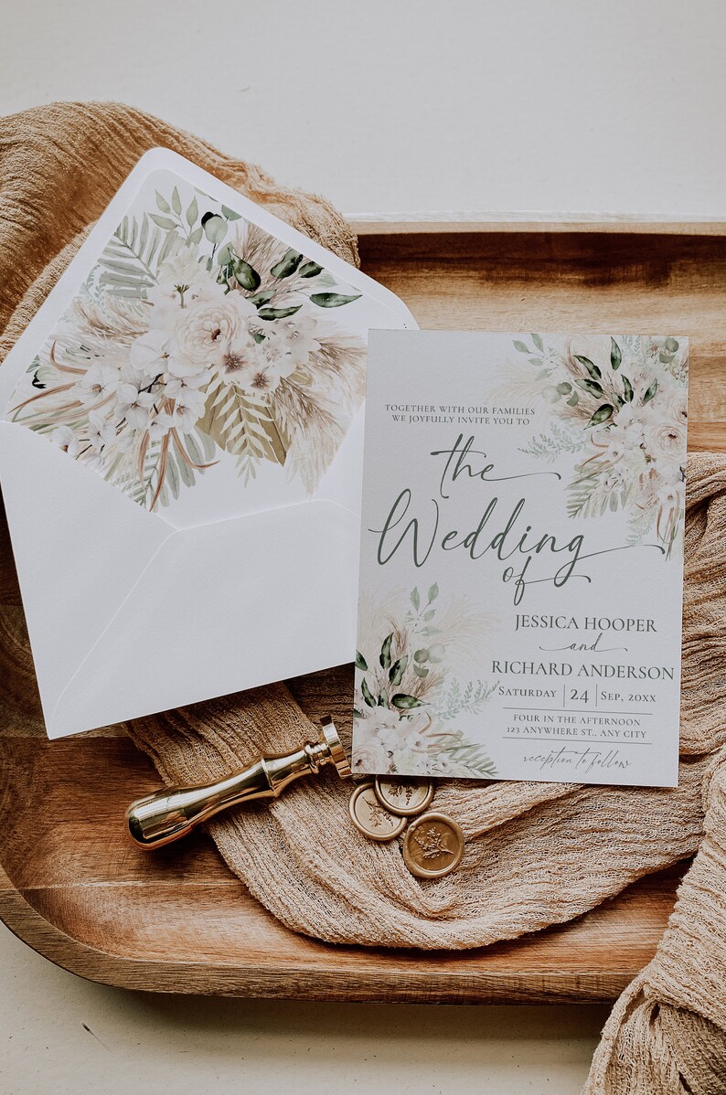 May include: A wedding invitation card and matching envelope featuring a floral and pampas grass design. The text reads: The Wedding of Jessica Hooper and Richard Anderson, Saturday 24 Sep, 20xx. A gold wax seal stamp and three circular wax seals are included.