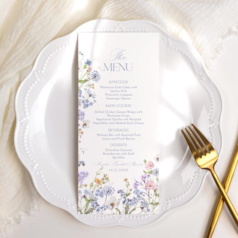 K&ouml;nnte beinhalten: Eine Hochzeitsmen&uuml;karte mit einem floralen Design mit blauen, violetten und rosa Blumen. Das Men&uuml; umfasst Vorspeisen, Hauptgericht, Getr&auml;nke und Desserts. Der Text auf der Karte lautet "The Menu", "Appetizer", "Miniature Crab Cakes with Lemon Aioli", "Prosciutto-wrapped Asparagus Spears", "Main Course", "Grilled Chicken Caesar Wraps with Parmesan Crumbs", "Vegetarian Quiche with Roasted Vegetables and Herbed Goat Cheese", "Beverages", "Mimosa Bar with Assorted Fruit Juices and Fresh Berries", "Desserts", "Chocolate Covered Strawberries with Gold Sprinkles", "Sarah's Bridal Shower", "14.12.20XX".