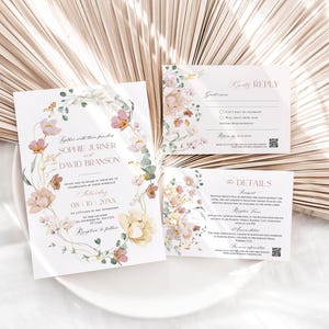 May include: Wedding invitation suite with floral design. The invitation features a watercolor illustration of pink and yellow flowers with green leaves. The text reads "Together with their families, Sophie Jurine and David Branson, Saturday, 08.10.20XX, at a location in the Arboretum, Reception to follow."