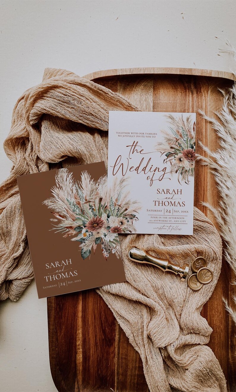 K&ouml;nnte beinhalten: Zwei Hochzeitseinladungen mit einem braunen und wei&szlig;en Blumendesign. Der Text auf den Einladungen lautet "The Wedding of Sarah and Thomas" und "Saturday 24 Sep. 20XX".