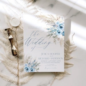 May include: A wedding invitation with a watercolor design featuring blue flowers and greenery. The text reads "Together with our families we joyfully invite you to the wedding of Jesica Hooper and Richard Anderson, Sunday, 24th July 20XX at 1 o'clock in the afternoon, at Anywhere, Any Street, Any City. Reception to follow."