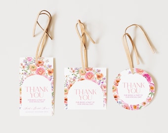 May include: Three gift tags with floral designs and leather strings. The tags have a white background with watercolor flowers in pink, peach, and purple. Each tag says "THANK YOU" in pink script. The tags are rectangular, square, and circular.