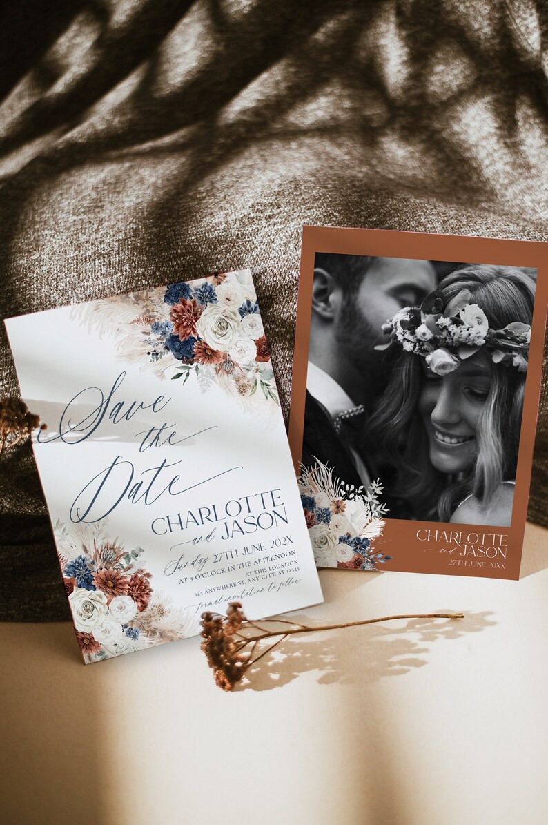 Może przedstawiać: Dwie prostokątne karty Save the Date z ilustracjami kwiatowymi w kolorze granatowym, rdzawym i kremowym. Jedna karta zawiera tekst Save the Date, Charlotte and Jason, Sunday 27th June 202X. Druga karta przedstawia czarno-białe zdjęcie pary.
