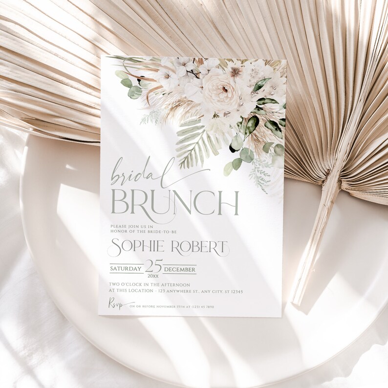 Może przedstawiać: Biało-zielone kwiatowe zaproszenie na brunch panieński z tekstem "bridal brunch" w szarym kolorze czcionki. Zaproszenie zawiera imię przyszłej panny młodej, Sophie Robert, datę, sobotę, 25 grudnia 20xx, oraz godzinę, 14:00. Miejsce to 123 Anywhere St, Any City, ST 12345. Informacje RSVP to 17 listopada najp&oacute;źniej pod numerem 1231 45 289.