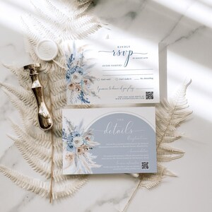 May include: A wedding RSVP card with a blue and white floral design. The card has a section for the guest's name, RSVP options, and a QR code. The text on the card reads "Kindly RSVP by August 20th" and "The Details".