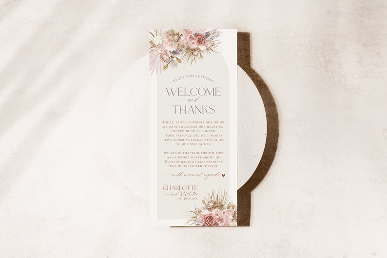 May include: A welcome and thank you sign for a wedding with a floral design in shades of pink, beige, and green. The text reads "Welcome and Thanks" with a message expressing gratitude to guests for their presence and well wishes. The sign is signed "Charlotte & Jason".
