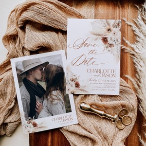 May include: Save the Date card featuring a floral design and a photograph of a couple kissing. The card reads "Save the Date" in cursive script and "Charlotte and Jason" in a serif font. The date is "27th June 202X".