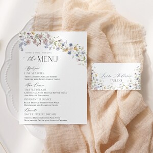 Pu&ograve; includere: Un menu di nozze con un design floreale. Il menu include antipasti, piatto principale e opzioni di dessert. La carta include anche un segnaposto con il nome "Lucas Andersen" e il numero del tavolo "01".