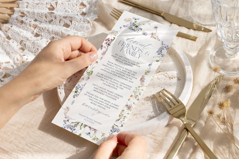 Puede incluir: Una tarjeta de invitaci&oacute;n rectangular para despedida de soltera con un borde floral de flores silvestres azules, moradas y verdes. El texto dice: Dearest Friends & Family, We are excited to have you join us for our bridal shower. Sarah's Bridal Shower 02.07.20XX.