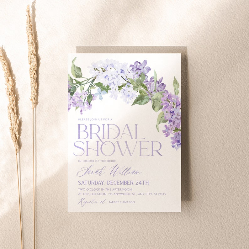 May include: A white bridal shower invitation with a purple floral design. The text reads 'Please join us for a Bridal Shower', 'In honor of the bride', 'Sarah William', 'Saturday, December 24th', 'Two o'clock in the afternoon', 'At this location, 123 Anywhere St, Any City, St 12545', 'Register at Target & Amazon'.
