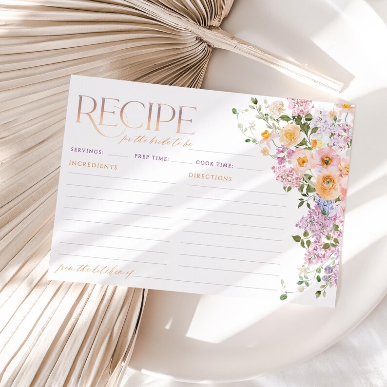 May include: A printable recipe card with a floral design in shades of pink, yellow, and purple. The card has sections for servings, ingredients, prep time, cook time, and directions. The text "RECIPE for the bride to be" is at the top of the card.