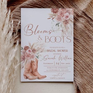 Op de afbeelding: Een rechthoekige uitnodigingskaart voor een bruidsdouche met de tekst Blooms & Boots, Sarah William, Saturday 24 Sep, 20XX en registerdetails. Het ontwerp bevat aquarelillustraties van bruine cowboylaarzen en roze boeketten met bloemen.