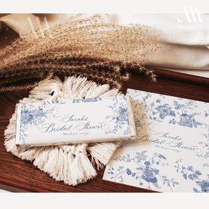 May include: A white chocolate bar wrapper with a blue floral design and the text "Sarah's Bridal Shower Thanks for coming!"