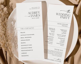 May include: Two elegant wedding ceremony programs on a white plate. The programs are white with black text, including the names "Audrey and James" and "The Wedding Party." The programs list the ceremony details and wedding party members.