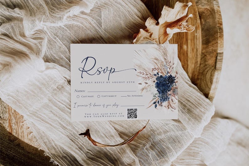 Op de afbeelding: Een rechthoekige RSVP-kaart met donkerblauwe schrijfletters en een bloemenillustratie met marineblauwe rozen en pampasgras. De kaart bevat lijnen voor namen, selectievakjes voor aanwezigheid, een QR-code en de tekst I promise to dance if you play.