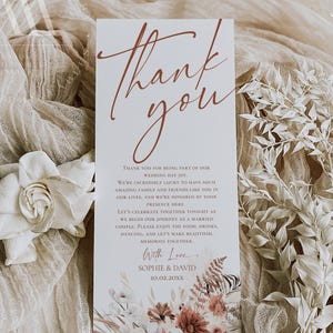 May include: A rectangular wedding thank you card featuring the text Thank you in a large rust-colored script font. Below, smaller text reads Thank you for being part of our wedding day joy, followed by With Love, Sophie & David, and 10.02.20XX.