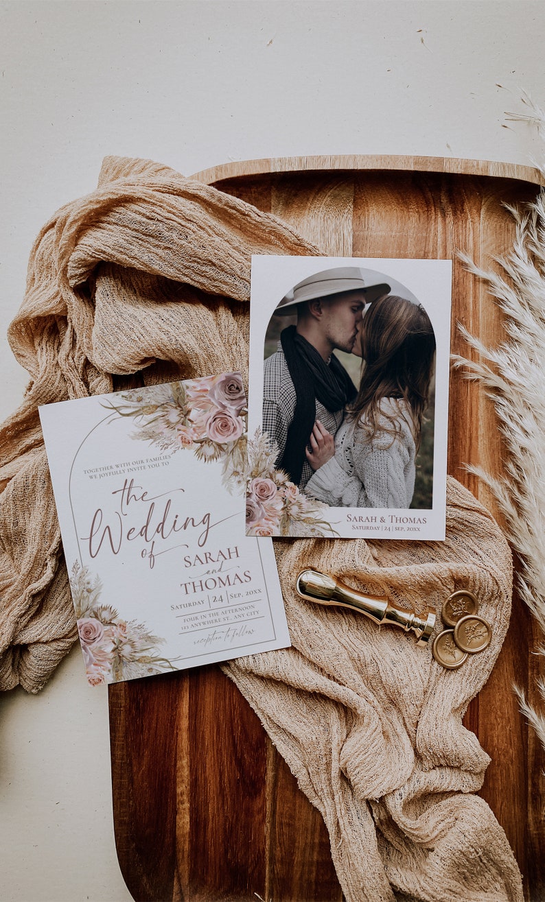May include: A wedding invitation set featuring floral illustrations of roses and pampas grass. The text reads: The Wedding of Sarah and Thomas, Saturday 24 Sep, 20XX. Includes a photo card of a couple, a gold wax seal stamp, and two wax seals.