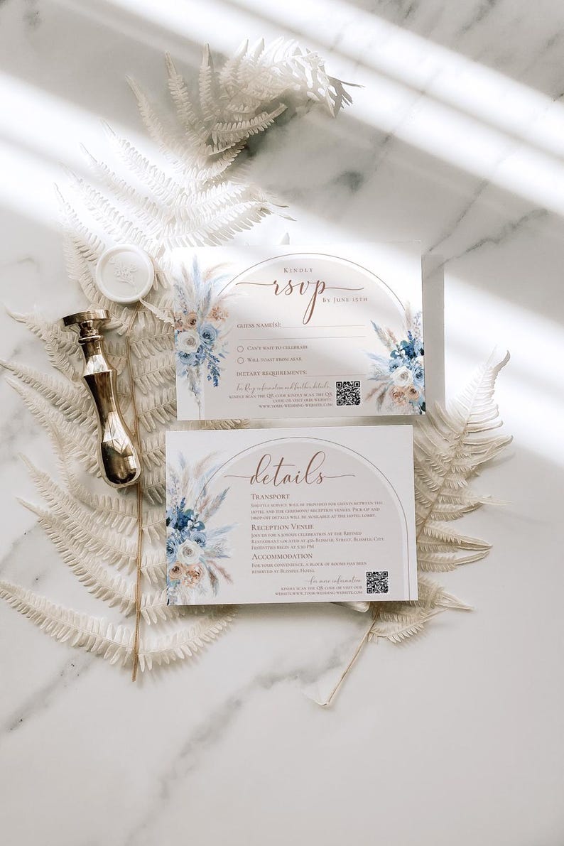 May include: Two rectangular white cards featuring blue and beige floral illustrations, an arched graphic, and text including RSVP and details. A gold metal wax seal stamp and a round white wax seal are positioned next to the cards.