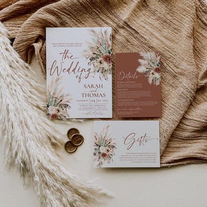 K&ouml;nnte beinhalten: Hochzeitseinladungssuite im Boho-Stil. Die Einladung zeigt eine Aquarell-Illustration von Pampasgras und Blumen in Rosa-, Braun- und Wei&szlig;t&ouml;nen. Der Text lautet "The Wedding of Sarah and Thomas, Saturday 24 Sep, 20xx, Four in the Afternoon, Anywhere St, Any City".