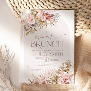 May include: A blush pink and gold bridal brunch invitation with a floral design. The text reads "bridal brunch" and "Please join us in honor of the bride-to-be Ashley Smith. Saturday 25 December 20xx. Two o'clock in the afternoon at this location 123 Anywhere St. Any City, ST 12345. RSVP on or before November 15th at (123) 45 7890."