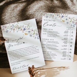 Puede incluir: Un conjunto de invitaciones de boda con un diseño floral. La parte delantera de la invitación presenta una ilustración de acuarela de flores azules y moradas con enredaderas verdes. El texto "We're so glad you're here" está escrito en una fuente de letra cursiva. La parte posterior de la invitación presenta un cronograma del fin de semana de la boda con el texto "Weekend Events" en la parte superior. El cronograma incluye eventos como el ensayo de la boda, la cena de ensayo, la ceremonia de la boda, la recepción de la boda y un brunch de agradecimiento.