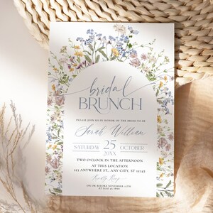 Pu&ograve; includere: Un invito per un brunch nuziale con la scritta "bridal BRUNCH" in elegante corsivo. L'invito include i dettagli dell'evento, come la data, l'ora e il luogo, circondato da un delicato bordo floreale.