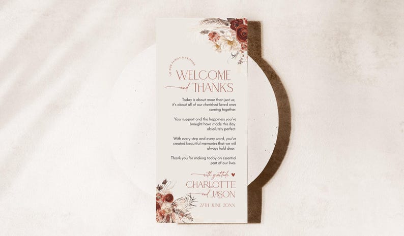 Puede incluir: Una tarjeta de bienvenida de boda rectangular con ilustraciones florales en burdeos y crema en la parte superior e inferior. El texto dice WELCOME and THANKS, seguido de un mensaje de gratitud, los nombres CHARLOTTE and JASON y la fecha 27TH JUNE 20XX.