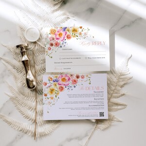 May include: Two white rectangular cards with floral watercolor illustrations in pink, orange, and yellow. The top card reads Kindly REPLY and the bottom card reads The DETAILS, including a QR code and text about transport, reception, and accommodation.