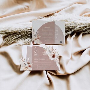May include: A light brown RSVP card with a floral design and the text "RSVP by [date]" printed on it. The card has a section for names and a checkbox to indicate whether the guest will attend or decline.