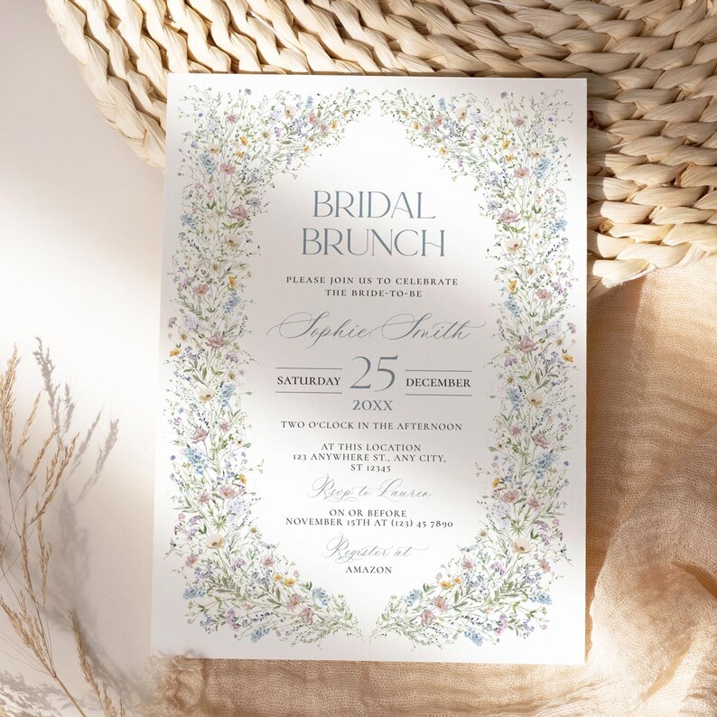 May include: A floral-themed bridal brunch invitation with a watercolor border of blue, pink, and yellow flowers. The text reads "Bridal Brunch", "Please join us to celebrate the bride-to-be", "Sophie Smith", "Saturday 25 December 20XX", "Two o'clock in the afternoon", "At this location", "121 Anywhere St., Any City, ST 12345", "RSVP to Lauren", "on or before November 15th at (123) 45 7890", "Register at AMAZON".