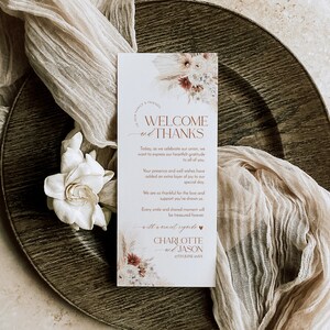 May include: A rectangular wedding welcome card with white background, featuring floral illustrations at the top and bottom. The text reads: WELCOME and THANKS, Today, as we celebrate our union, we want to express our heartfelt gratitude to all of you. CHARLOTTE and JASON 27TH JUNE 20XX.