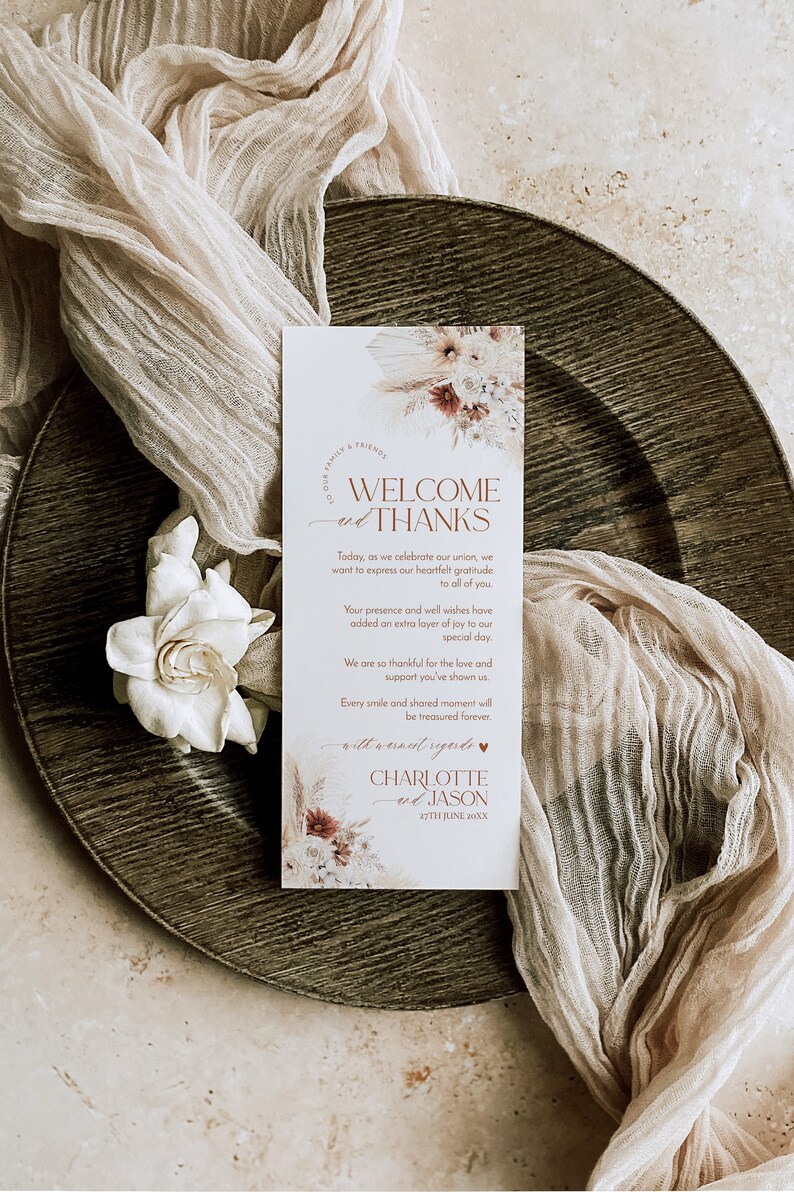 May include: A rectangular wedding welcome card with white background, featuring floral illustrations at the top and bottom. The text reads: WELCOME and THANKS, Today, as we celebrate our union, we want to express our heartfelt gratitude to all of you. CHARLOTTE and JASON 27TH JUNE 20XX.