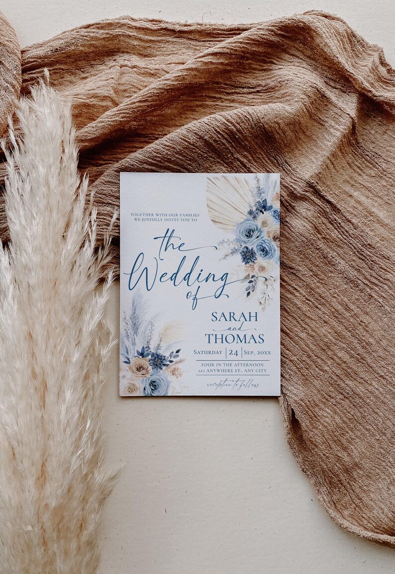 May include: A wedding invitation with a blue and beige floral design. The text reads "Together with our families we joyfully invite you to the wedding of Sarah and Thomas, Saturday 24 Sep, 20XX, Four in the afternoon, at Anywhere St, Any City, reception to follow."